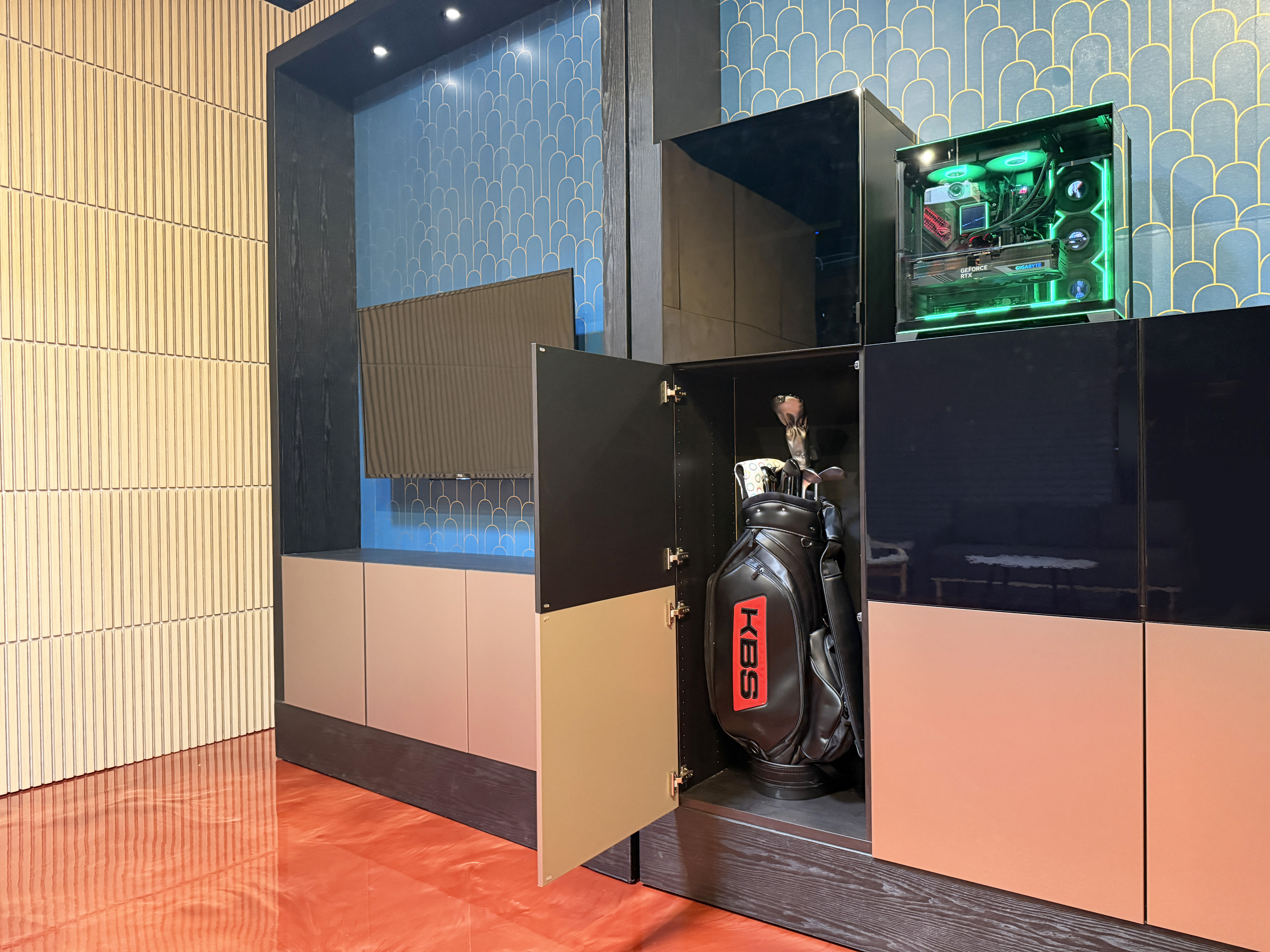 Indoor golf enclosure with concealed storage cabinet for golf clubs, accessories, and gaming PC, maintaining a clean and organized room.