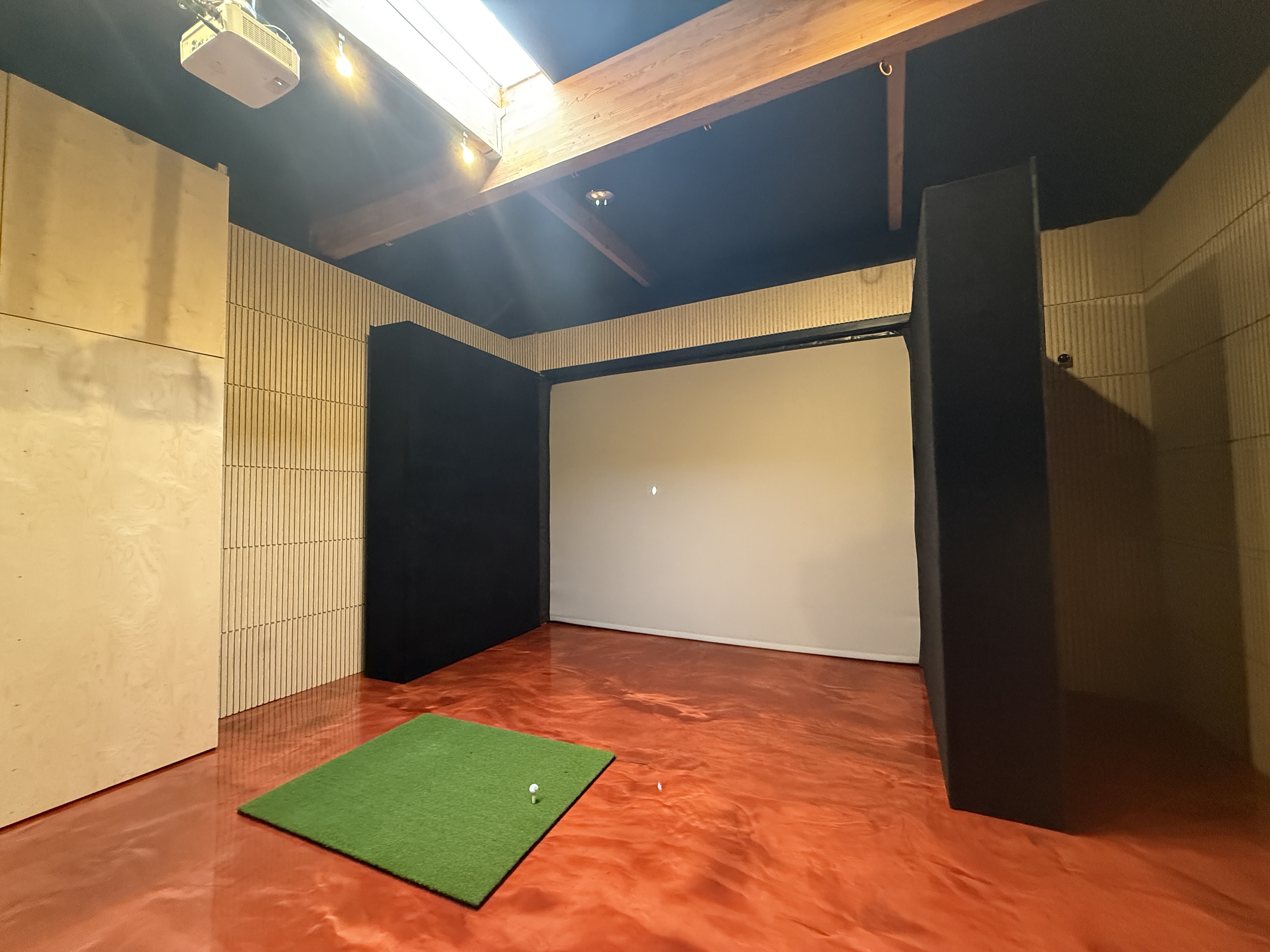 Home indoor golf simulator enclosure with impact screen, ball containment panels, and hitting mat to help protect the room during golf practice.